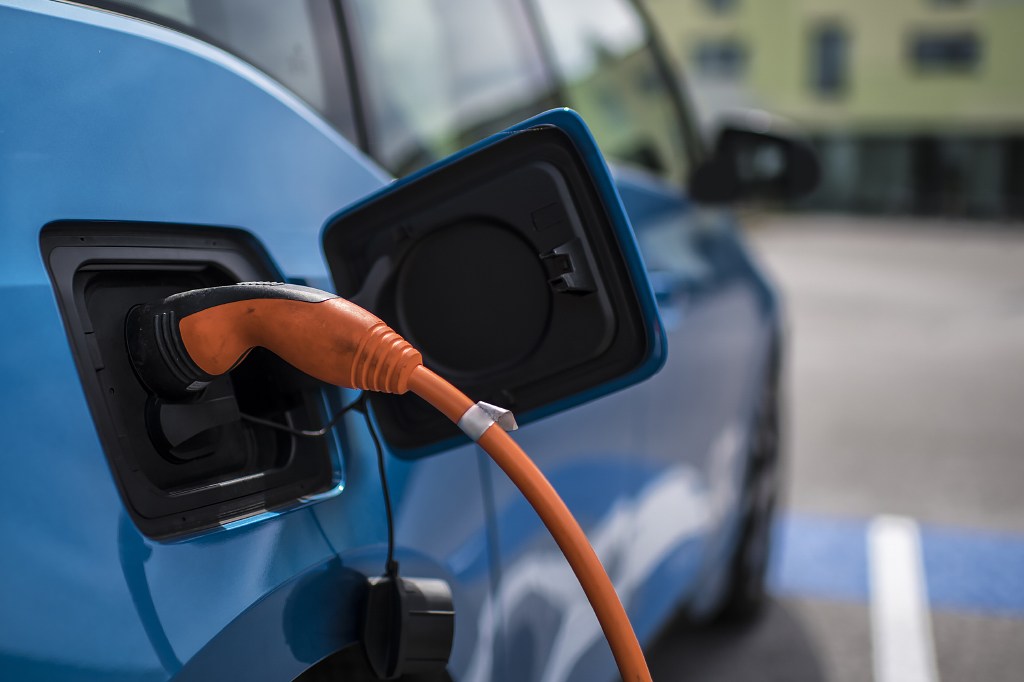 Electric vehicle plugged in to a charging cable.